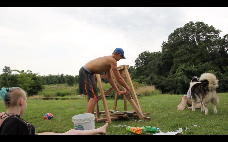 A homemade 2x4 A-frame trebuchet being tested in a field